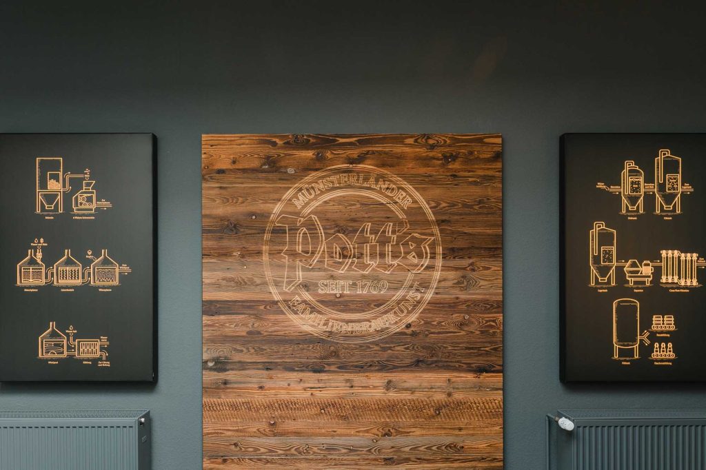Pott´s Logo in Holz geschnitzt, Nahaufnahme der Wand.