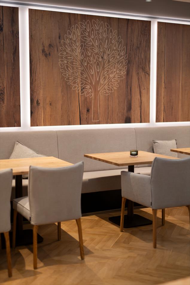 Sitzecke im Restaurant Albermann mit geschnitzter Grafik an der Wand.